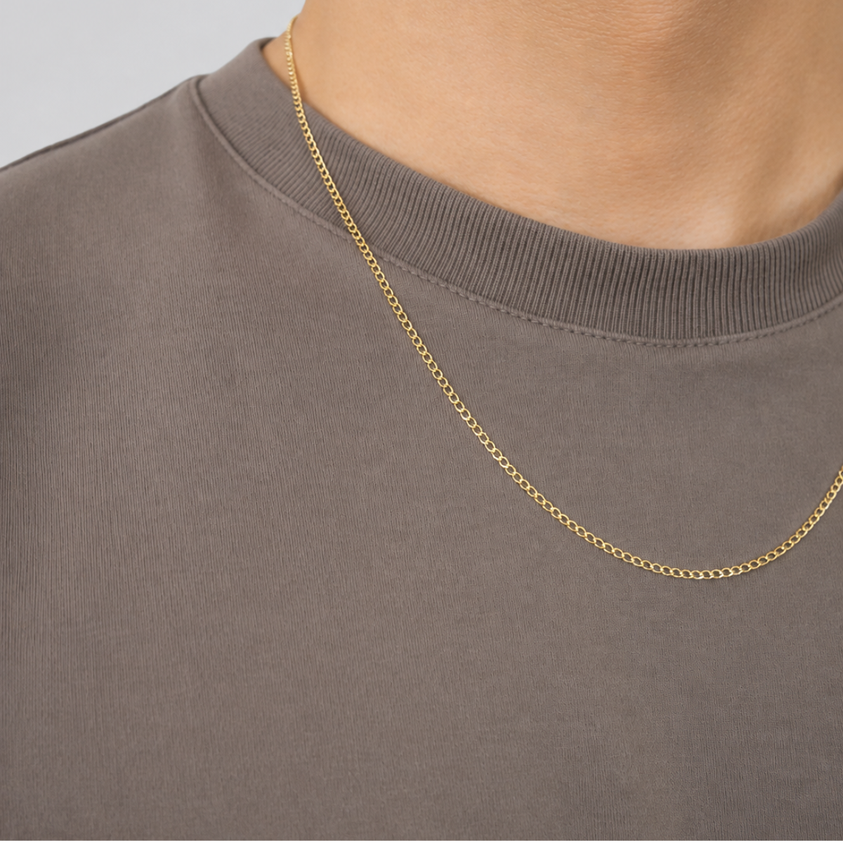 Cadena barbada oro 10k puesta en hombre con playera gris, vista de pecho – CRIXUS Joyería